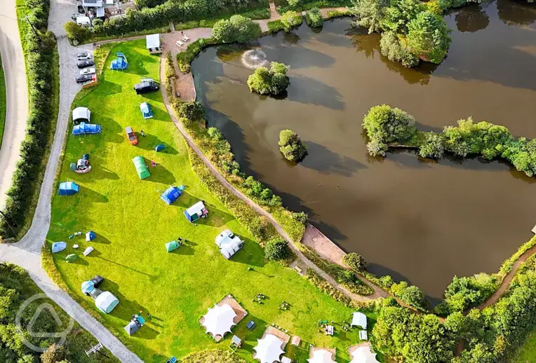 Bird's eye view of Tregonetha Lake with camping pitches by the water