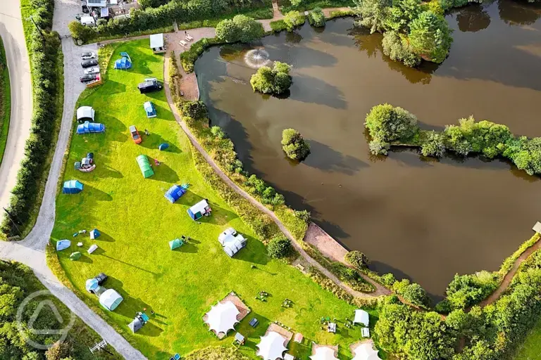 Bird's eye view of Tregonetha Lake with camping pitches by the water