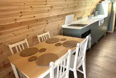 Dining table and equipped kitchenette with a hob, freezer/fridge and kitchenware Dining table and equipped kitchenette with a hob, freezer/fridge and kitchenware
