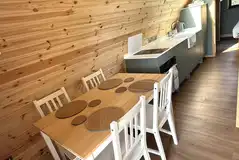 Dining table and equipped kitchenette with a hob, freezer/fridge and kitchenware