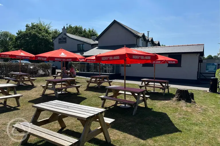 Outdoor seating area at the pub with picnic tables and umbrellas