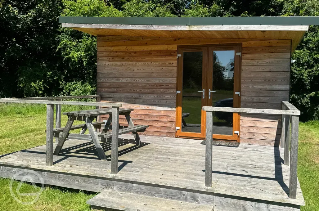 Fully furnished glamping lodge with private decking and picnic benches