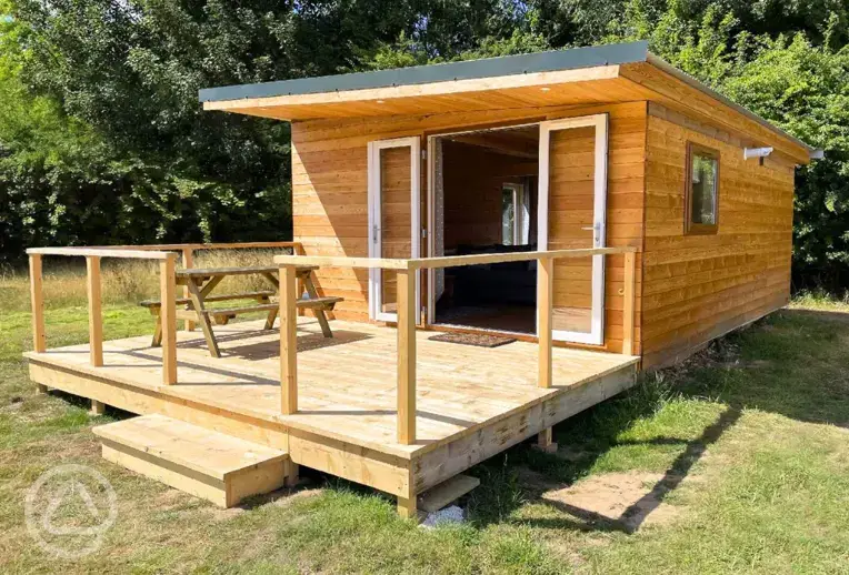 Fully furnished glamping lodge with private decking and picnic benches