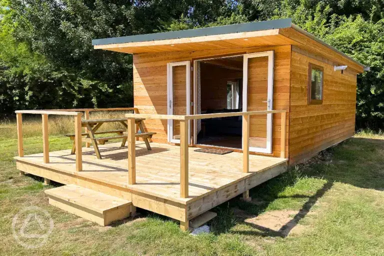 Fully furnished glamping lodge with private decking and picnic benches