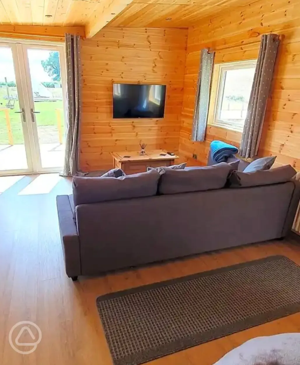 Glamping lodge L-shaped sofa and TV