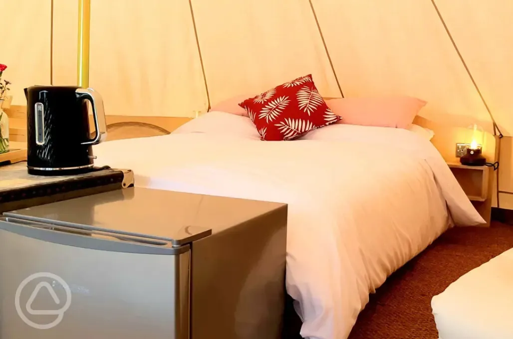 Bell tent king size bed, mini fridge and kettle