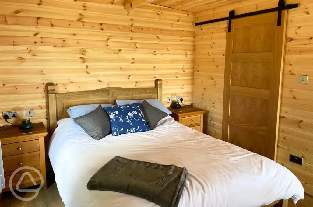 Glamping lodge king size bed and ensuite bathroom