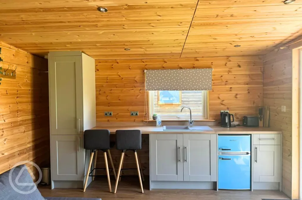 Glamping lodge kitchen area with stools