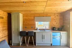 Glamping lodge kitchen area with stools