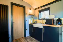 Shepherd's hut kitchen with a fridge, microwave, kettle and toaster