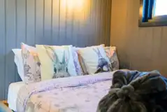 Shepherd's hut interior with a queen size bed with bedding