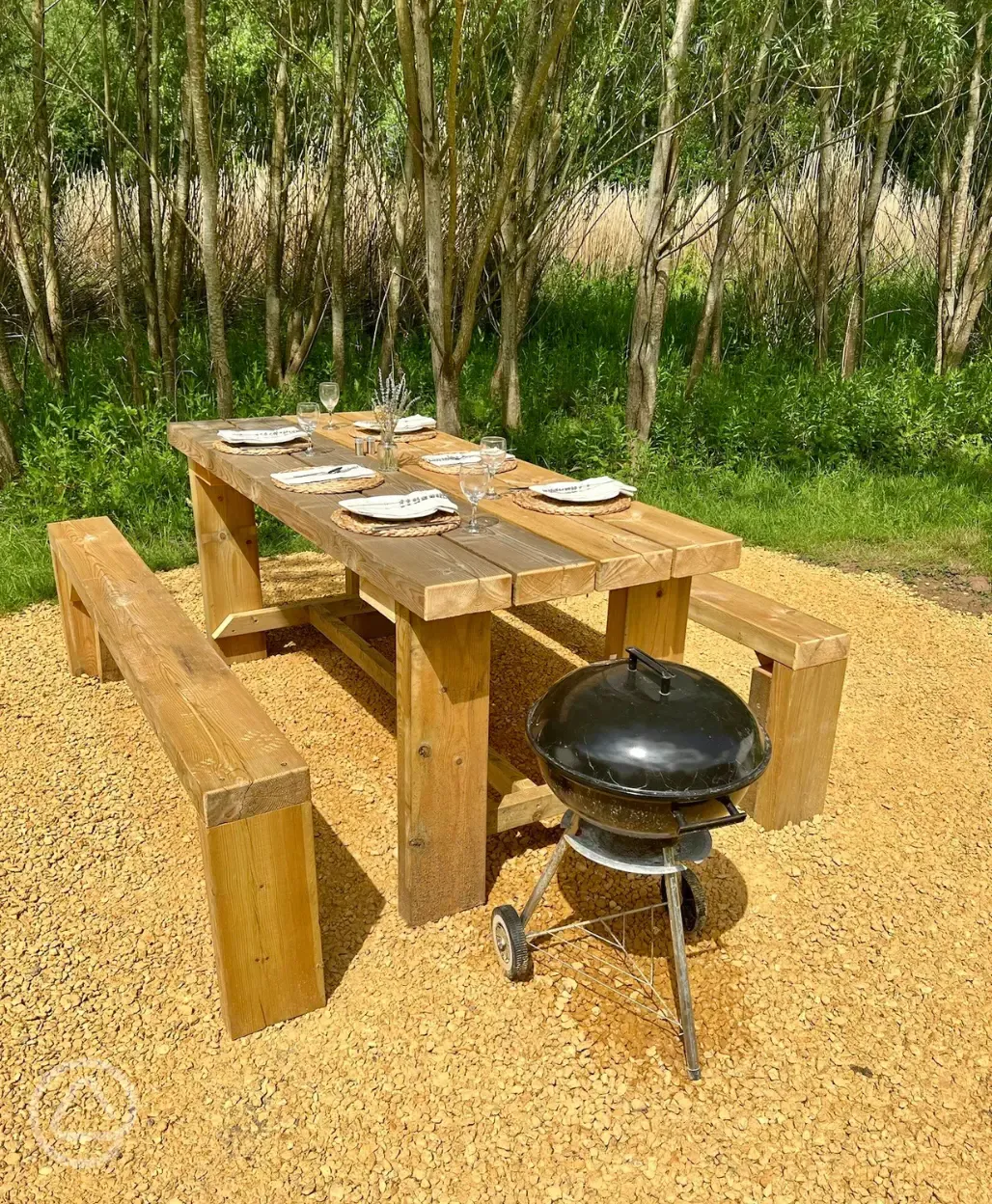 Picnic bench and BBQ outside the bell tents