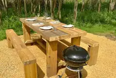 Picnic bench and BBQ outside the bell tents