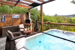 Private outdoor area with a BBQ, a chimenea and a hot tub with waterside views