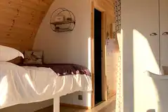 Pod interior with a double bed and dividing curtain