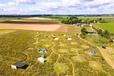 Aerial of Hatters Meadow with grass pitches and glamping