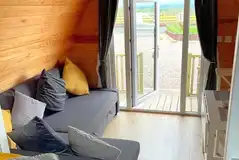 Glamping pod sofa bed with views of the Cumbrian countryside