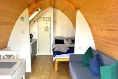Glamping pod interior with double bed, sofa bed and kitchenette