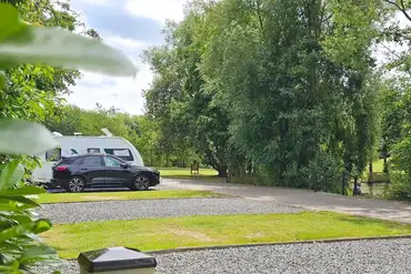 Fully serviced hardstanding pitches with a car parked beside