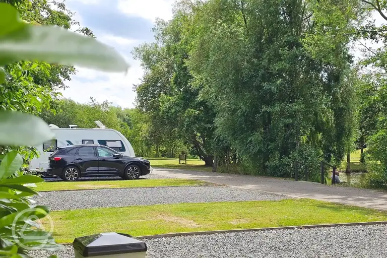 Fully serviced hardstanding pitches with a car parked beside