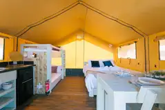 Family safari tent with a double bed and bunk beds