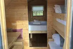 Camping pod interior with a king size bed and bunks Camping pod interior with a king size bed and bunks
