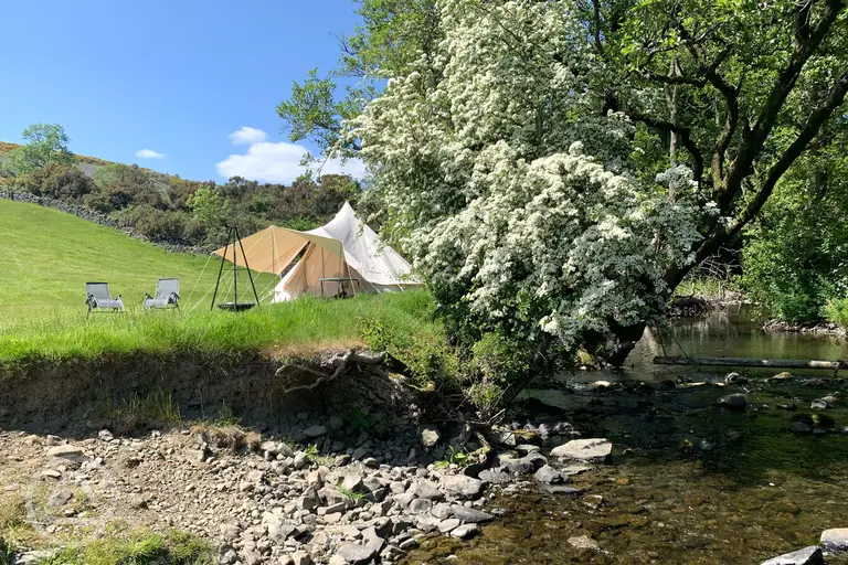 Alders Edge bell tent with outdoor seating, a fire pit and waterside views