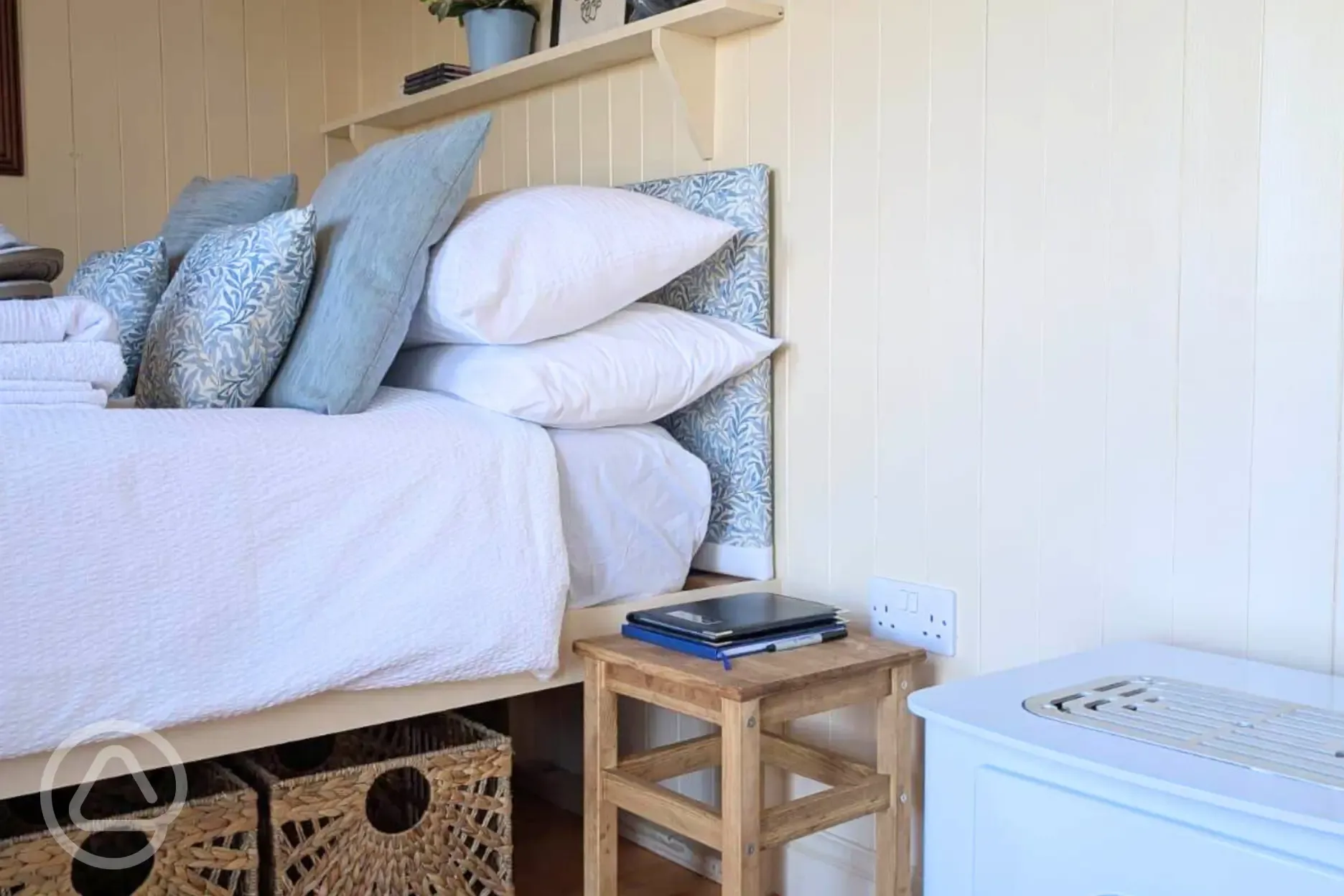 Skyland shepherd's hut double bed with storage and a bedside table