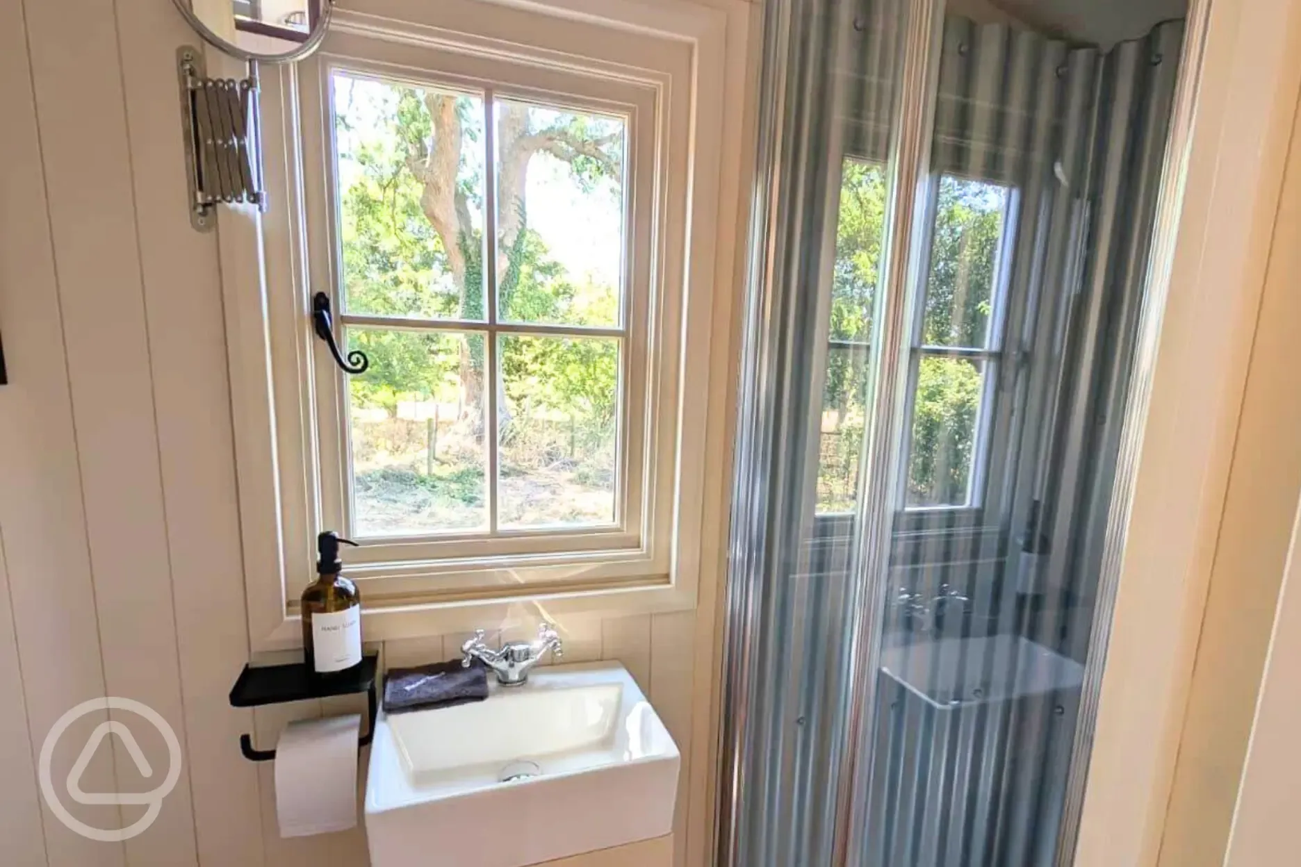 Skyland hut ensuite with a toilet, sink, shower, towels and toiletries