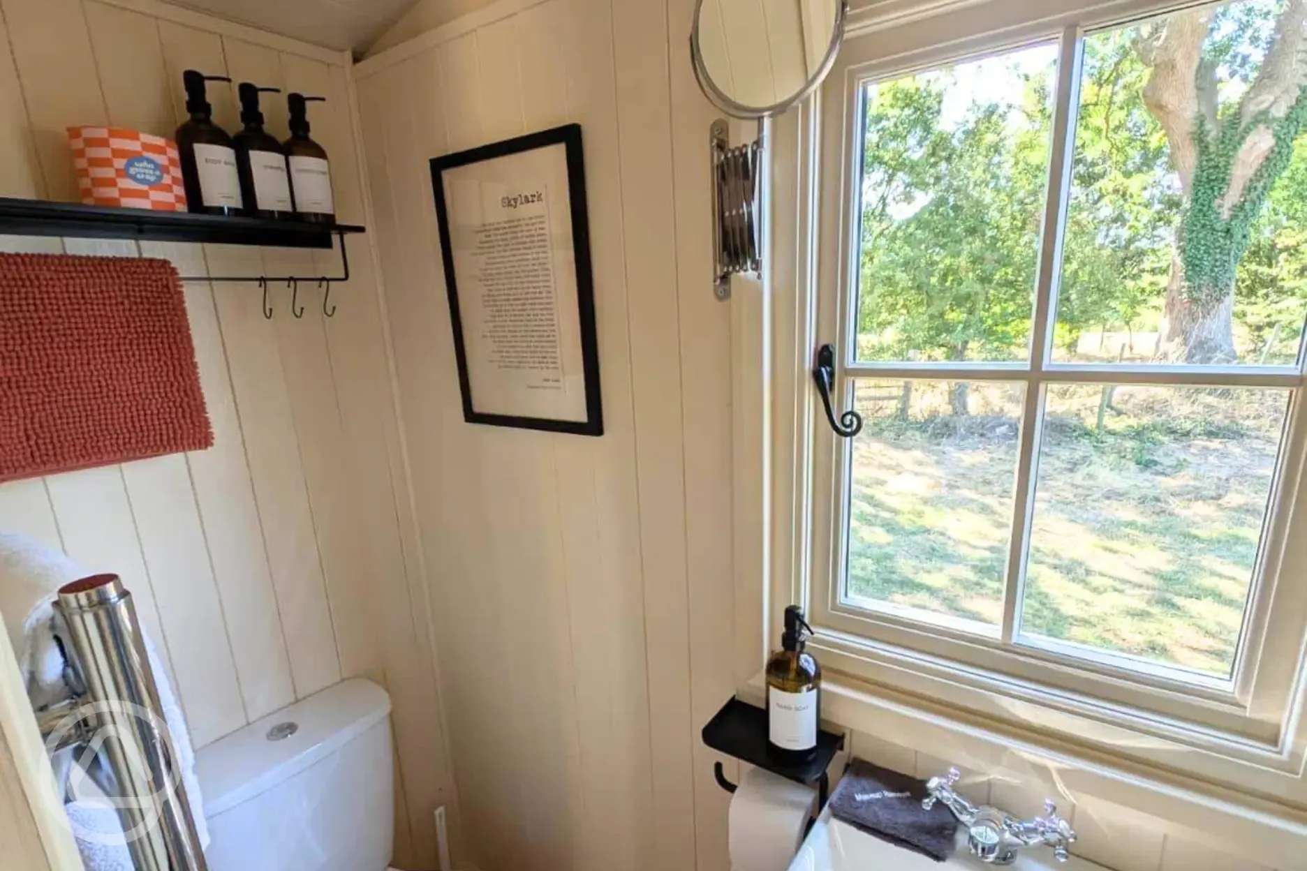 Skyland hut ensuite with a toilet, sink, shower, towels and toiletries