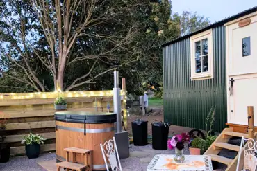 Skyland shepherd's hut with a wood-fired hot tub, fire pit and patio