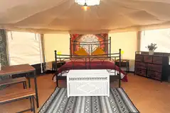 Yurt interior at Old Park Cottage Camping with a king sized bed and furniture Yurt interior at Old Park Cottage Camping with a king sized bed and furniture