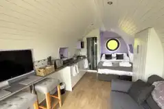 Glamping pod interior with a double bed and double sofa bed