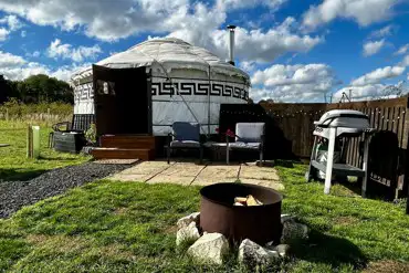 Primrose Yurt patio with outdoor seating, fire pit, and BBQ