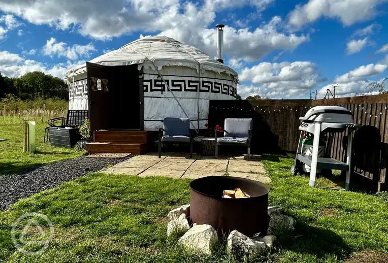 Primrose Yurt patio with outdoor seating, fire pit, and BBQ