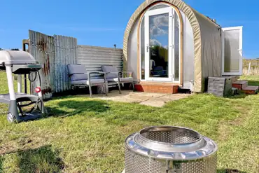 Coco Pod private patio with outdoor seating, fire pit, and BBQ