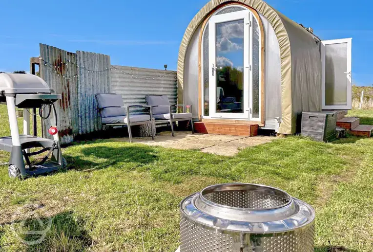 Coco Pod private patio with outdoor seating, fire pit, and BBQ