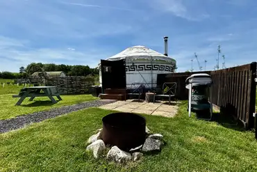 Primrose Yurt patio with outdoor seating, fire pit, and BBQ