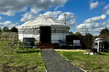 Primrose Yurt patio with outdoor seating, fire pit, and BBQ