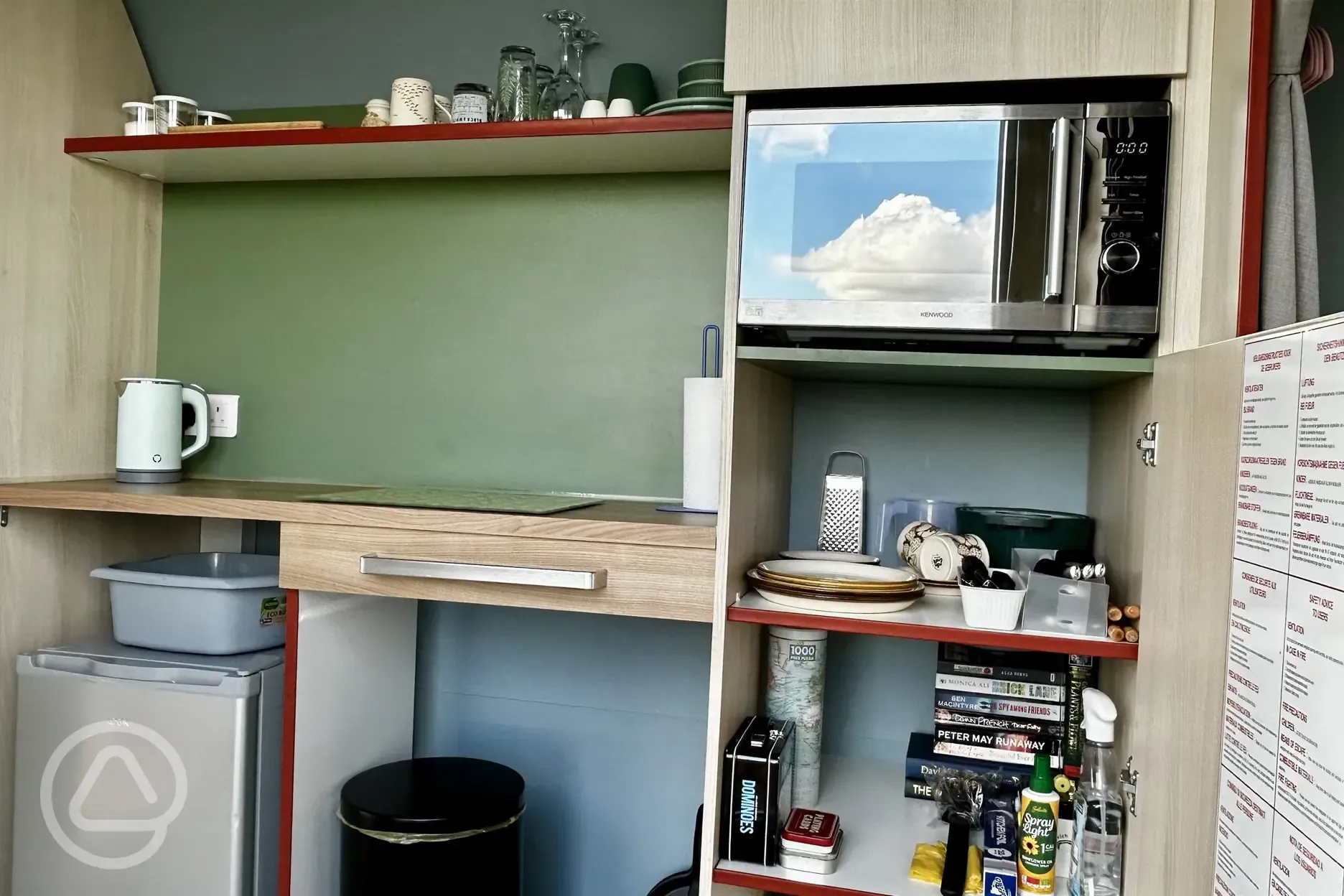 Coco Pod campers kitchen with fridge, kettle, microwave, and utensils