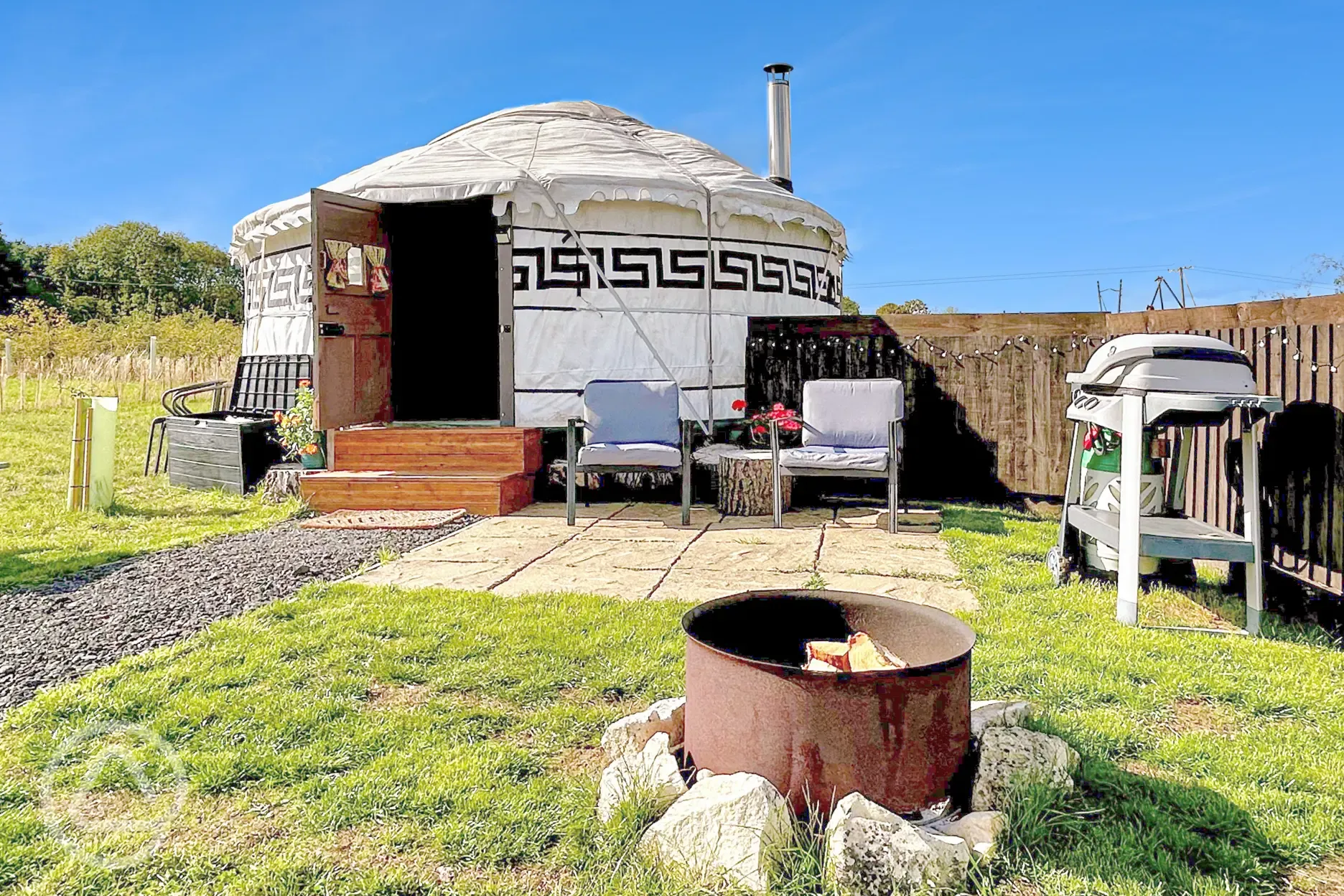 Primrose Yurt patio with outdoor seating, fire pit, and BBQ