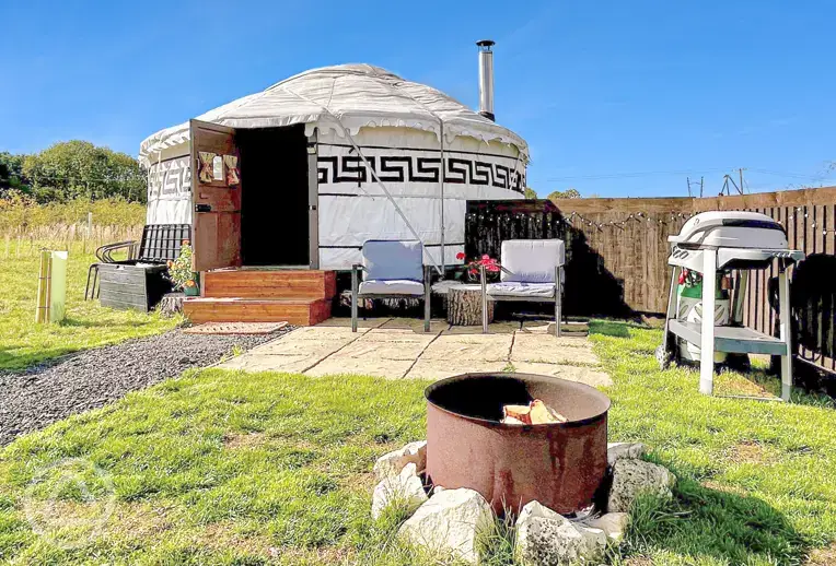 Primrose Yurt patio with outdoor seating, fire pit, and BBQ