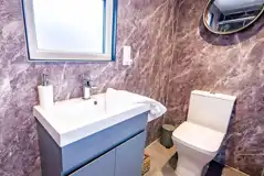 Cabin ensuite shower room with toilet and handwashing sink
