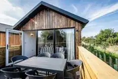 Cabin with glass doors and a private outdoor decking with seating