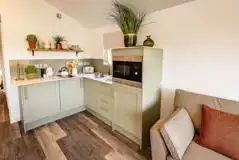 Cabin kitchen with a fridge/freezer, microwave, kettle, hob, sink and toaster