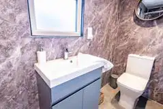 Cabin ensuite bathroom with toilet, hand basin, shower and towels