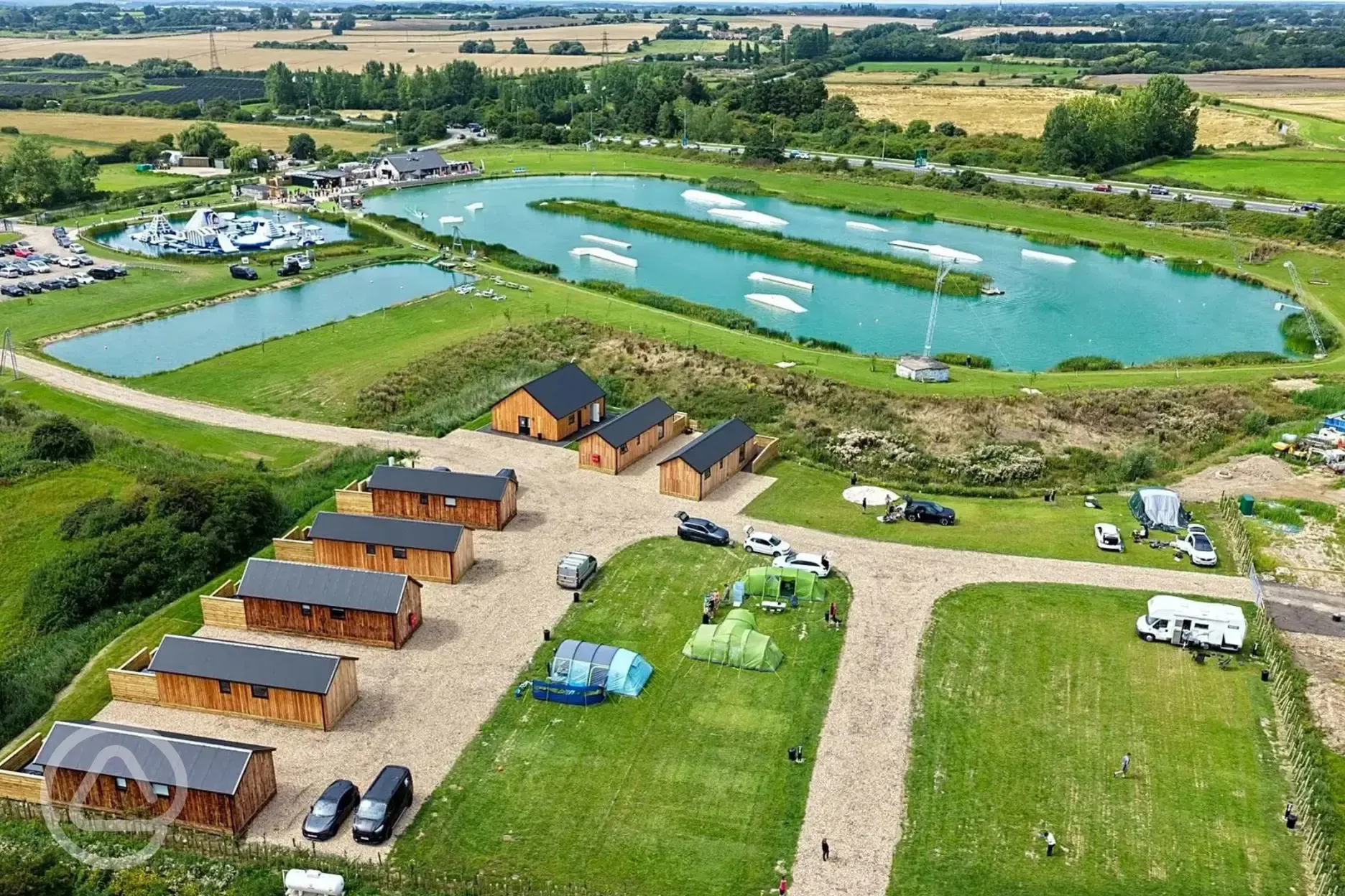 Aerial view of grass pitches, ensuite cabins and aqua park at Whitemills Wake Aerial view of grass pitches, ensuite cabins and aqua park at Whitemills Wake