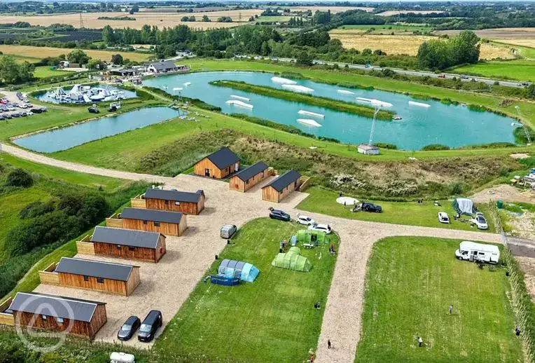 Aerial view of grass pitches, ensuite cabins and aqua park at Whitemills Wake