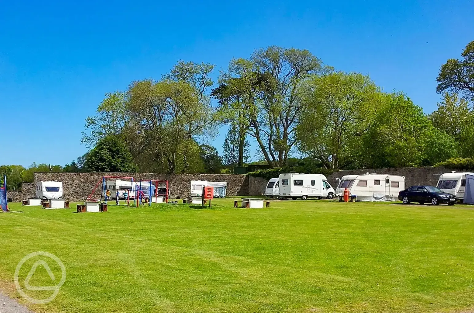 Grass touring pitches with children's play park in the centre