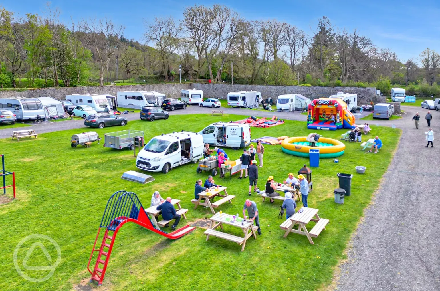 Touring pitches and play park on a bank holiday weekend with bench seating